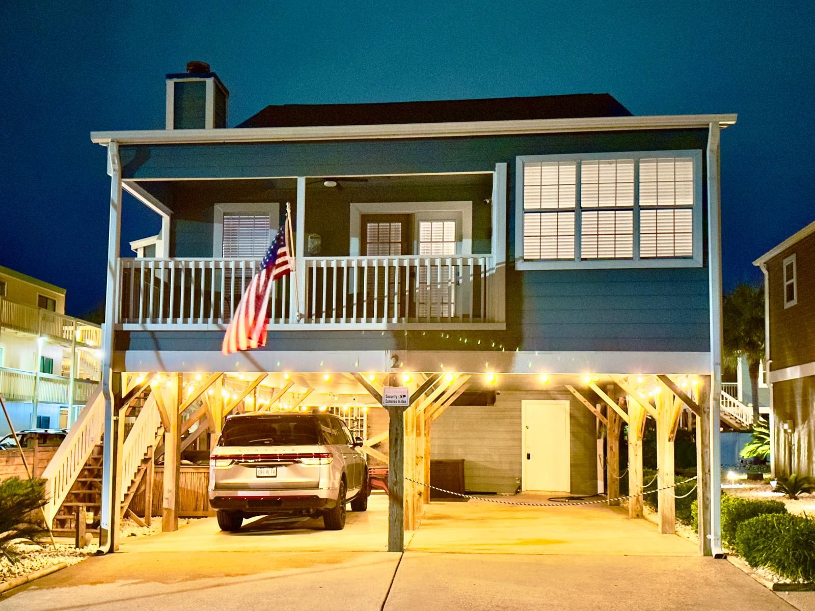 A two-story building with a garage entrance, an American flag, and a staircase leading to the upper level.