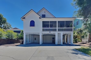 Ein zweistöckiges Haus mit Balkon, Garage und Auffahrt.