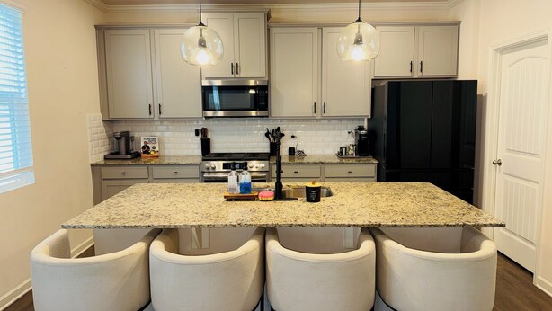 A kitchen with granite countertops, stainless steel appliances, and four bar stools. - Family Friendly and Group Stay 4BR Home, Sleeps 8 Near ATL Airport (Fairburn)