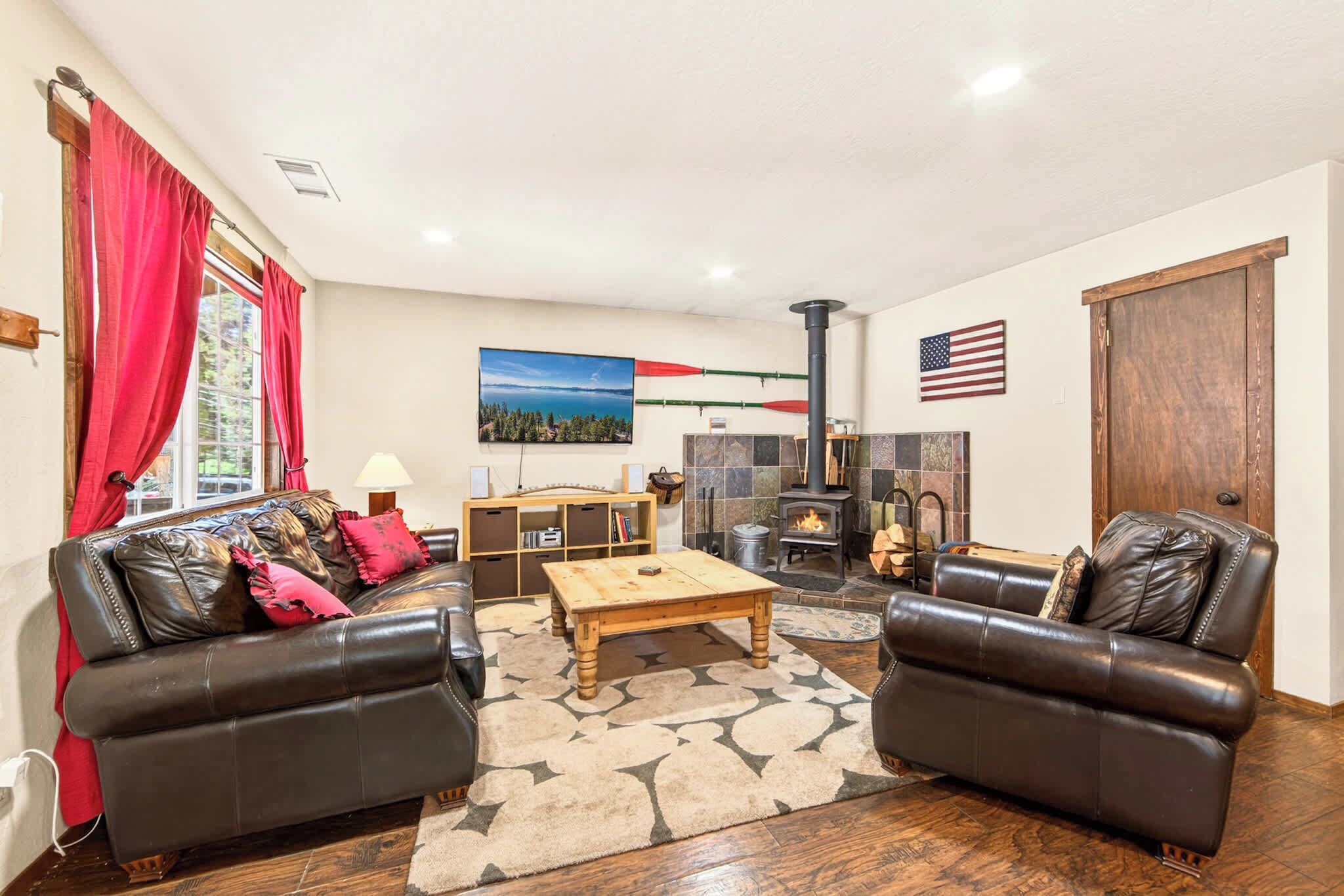 A living room with a fireplace, leather sofas, a coffee table, and a bookshelf.