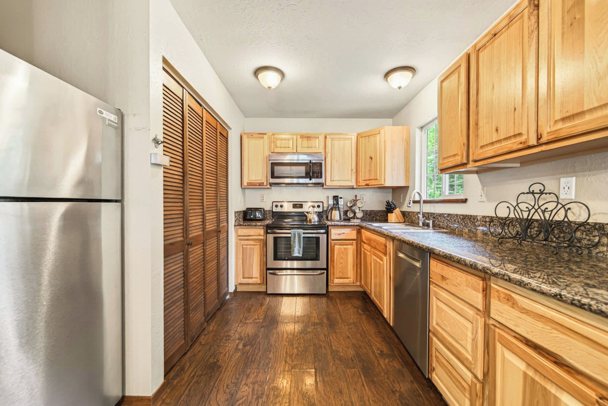 A kitchen with wooden cabinets, stainless steel appliances, and a granite countertop.