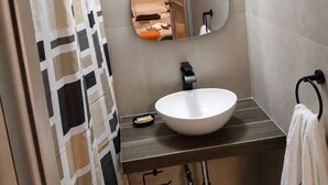 A bathroom with a shower curtain, a round mirror, a sink, and a towel rack. - Private Rooms Across from the Plaza de Armas, Private Bathroom, Beautiful View 4 (Arequipa)