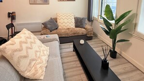 Een moderne woonkamer met een bank, een salontafel en een groot raam.