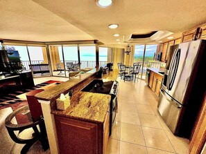A spacious kitchen with a large island, modern appliances, and a view of the ocean. - Lux Oceanfront Villa Condo on 14th Flr & Amenities (Myrtle Beach)