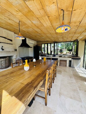 Eine geräumige Küche mit Holztisch, Stühlen und Pendelleuchten.