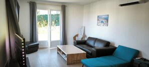 Una sala de estar con un sofá, una mesa de centro y un televisor.