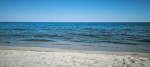 Ein Strand mit klarem, blauem Wasser und einem Sandufer.
