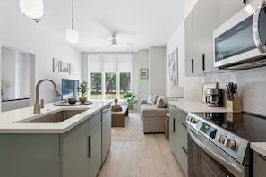Eine moderne Küche mit Einbauofen, Mikrowelle und einem großen Fenster.
