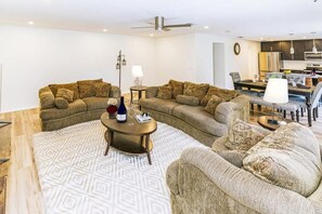 Ein Wohnzimmer mit zwei Sofas, einem Couchtisch und einem Essbereich mit Tisch und Stühlen.