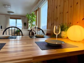 A dining table with plates, a glass, and a candle. - Luxury Toya Villa: Lake Views, BBQ, Cinema & Hammock (Toyako)