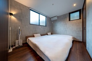 Un dormitorio moderno con una cama grande, un calentador independiente y una ventana.