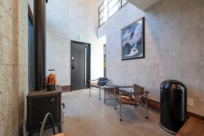 Un vestíbulo con chimenea, zona de estar y un cuadro en la pared.
