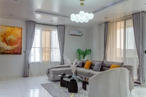A modern living room with a sofa, coffee table, and a painting on the wall.