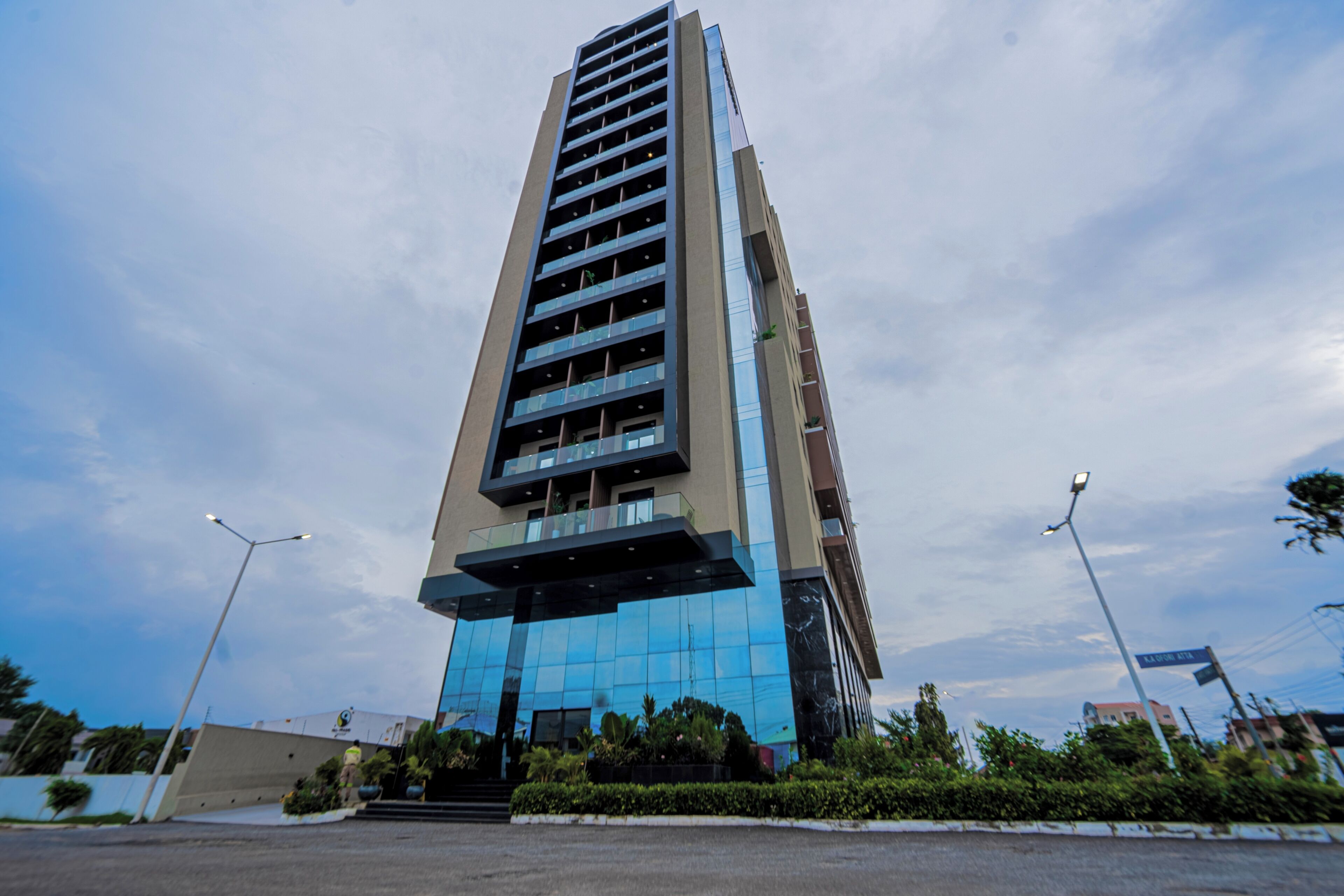 A tall, modern building with multiple floors, large windows, and a reflective glass facade.