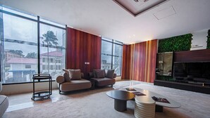 Un salon moderne avec un canapé d’angle, une table basse et un espace dédié à la télévision.