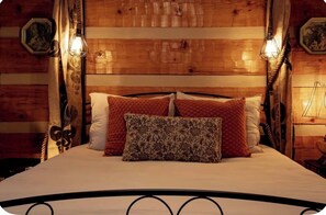Ein Zimmer aus Holz mit einem Bett, zwei Wandleuchten und einer Wanddekoration.