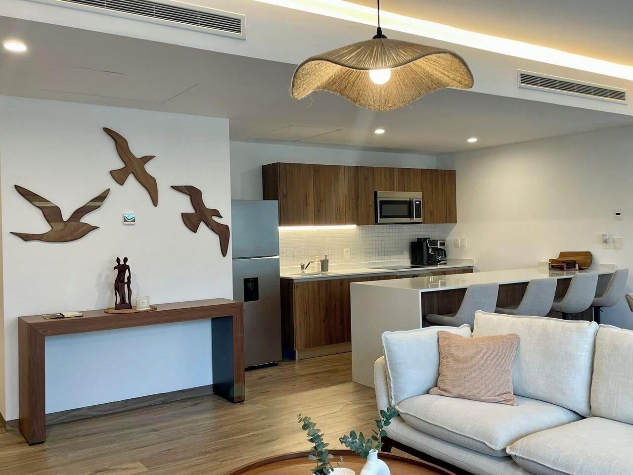 Ein stilvolles Wohnzimmer mit Sofa, Konsolentisch und Wandbildern.