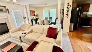 A living room with a sectional sofa, a coffee table, a TV, and a fireplace.