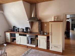Eine Küche mit Geschirrspüler, Backofen und Kaffeemaschine auf der Arbeitsfläche.