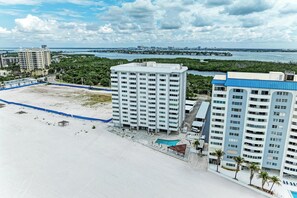Ein Hochhaus-Hotel mit Pool, Strandzugang und Blick auf die Stadtlandschaft.