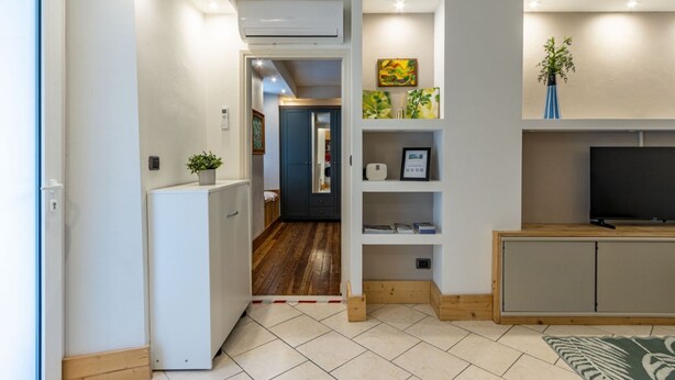 A compact living space with a kitchenette, a television, and a small seating area.