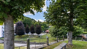 A park with a bench, trees, and a playground.
