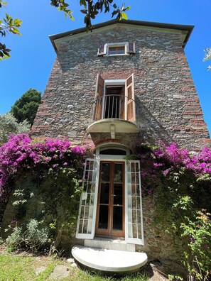 A stone building with a balcony, a window with shutters, and a door with glass panels. - Charming House by the Sea in Liguria (Cinque Terre, Porto Venere, Lerici by Boat) (Bocca di Magra)