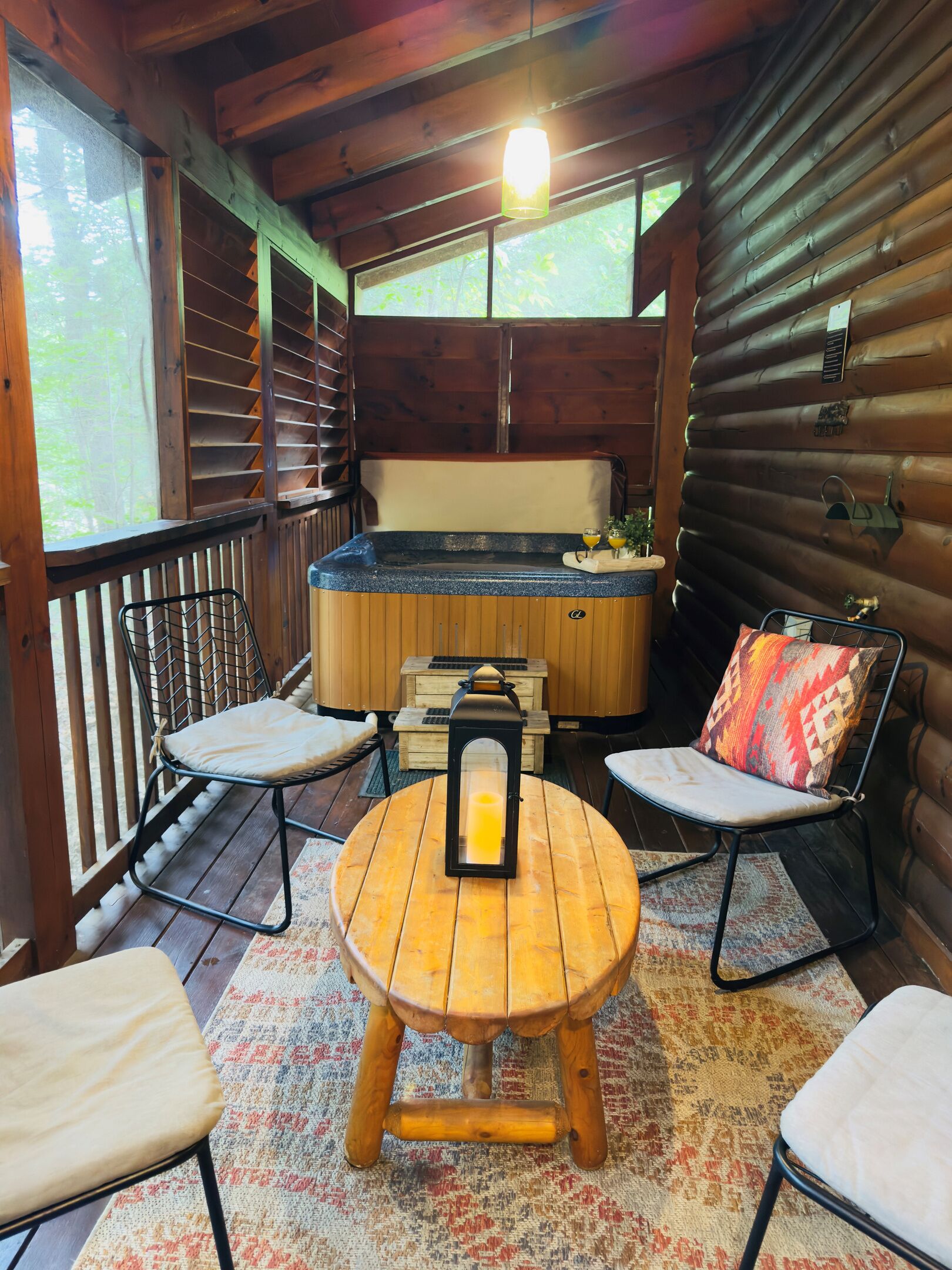 Une cabane en bois avec un jacuzzi, une table en bois et deux chaises.