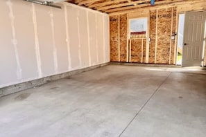 Habitación sin terminar con estructura de madera a la vista y piso de concreto.