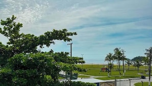 Vista de una playa con palmeras, un parque infantil y un edificio en primer plano.