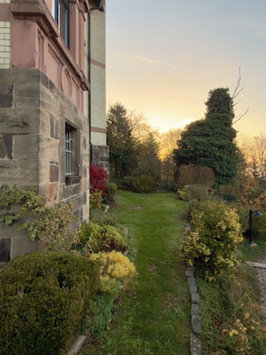 Un edifici de pedra amb un camí de jardí que condueix a un pràt.