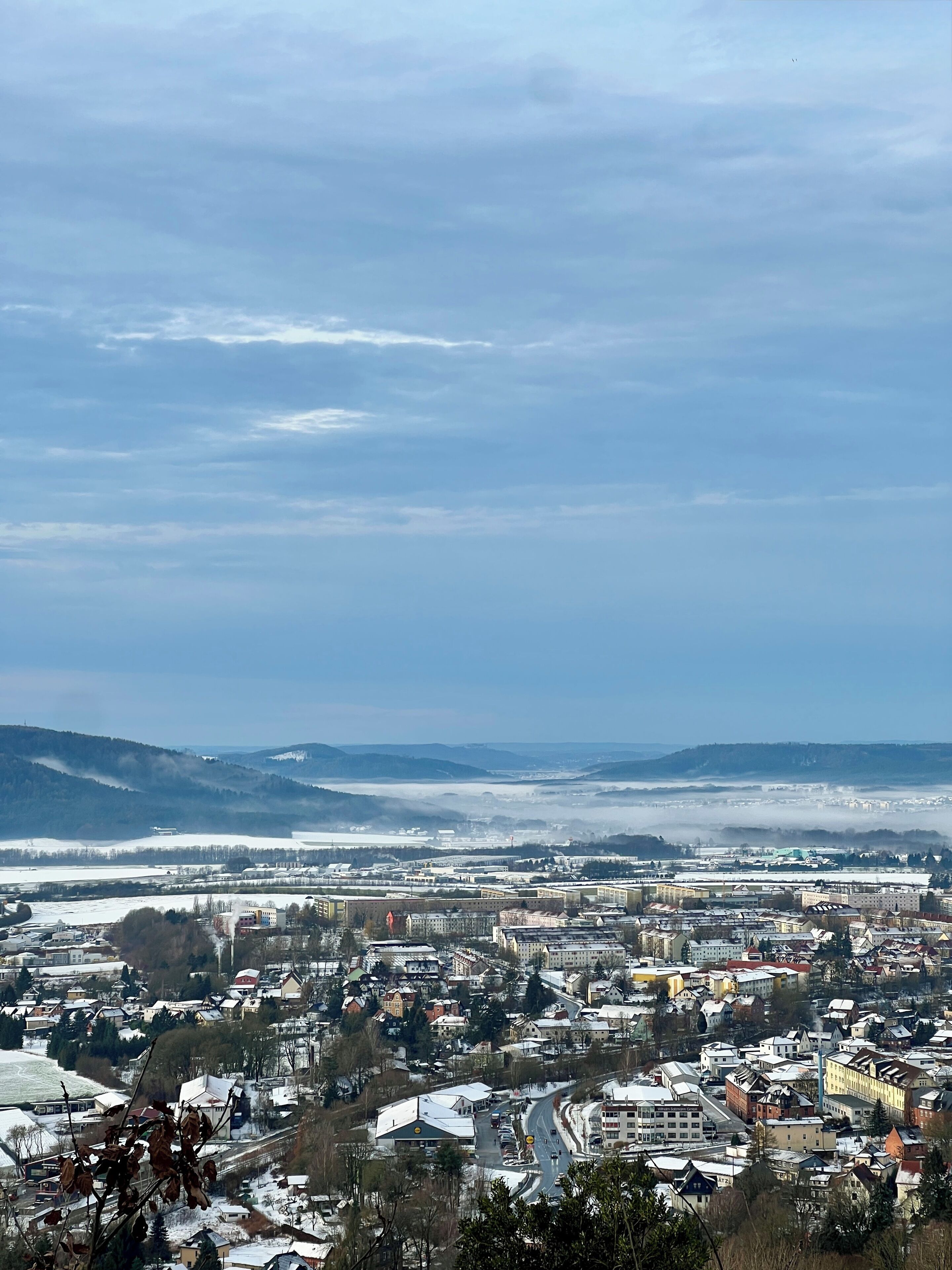 Een panoramisch uitzicht op een stad met besneeuwde gebouwen en een heldere lucht.