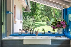A kitchen with a window, sink, and gas stove. - Moulin de Lassalle (Linxe)