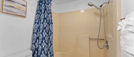 Een douche met douchekop en glazen deur.