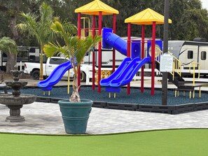 A playground with slides and a fountain.