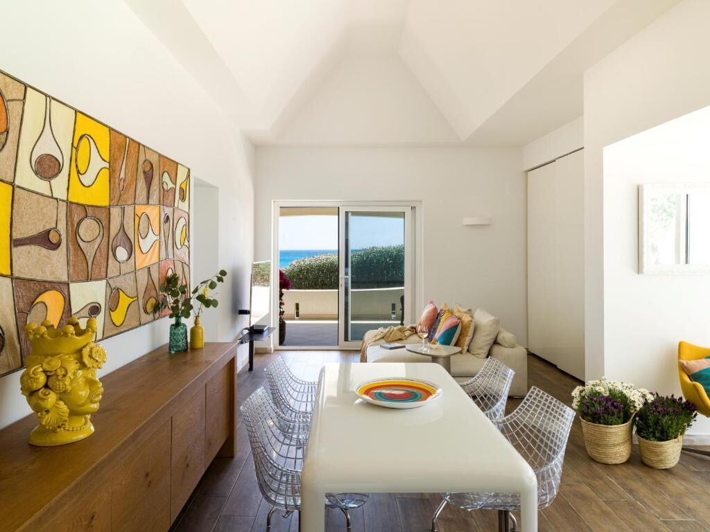 Un salon moderne avec une table à manger, un canapé et une grande œuvre d’art abstraite accrochée au mur.