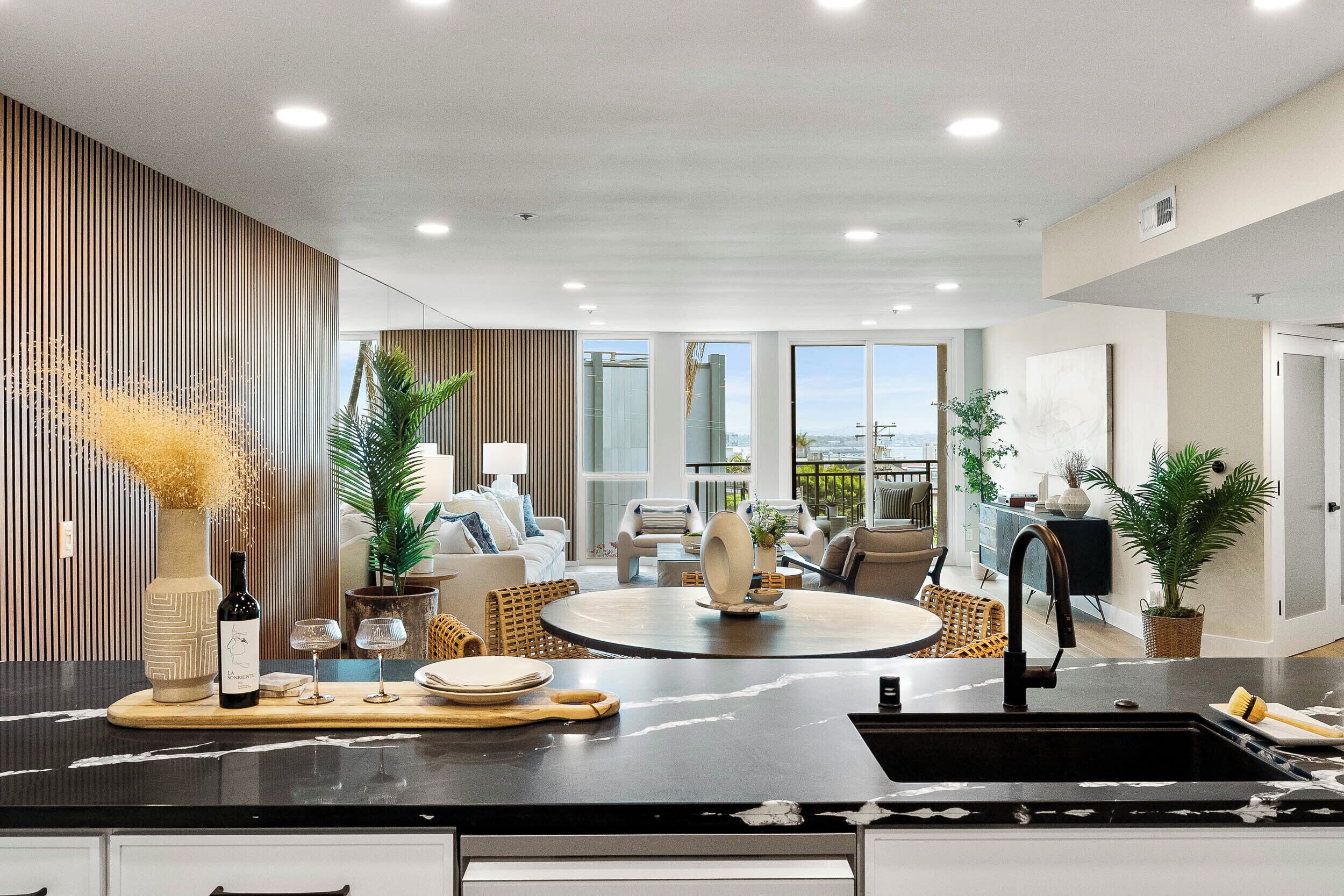 Una cocina moderna con una isla central, un comedor con una mesa redonda y vistas al exterior.