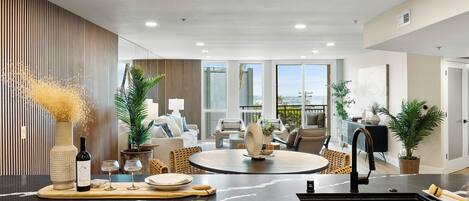 Una cocina moderna con una isla central, un comedor con una mesa redonda y vistas al exterior.