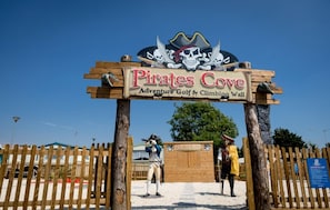 Un letrero de madera que dice 'Pirates Cove Adventure Golf & Climbing Wall'.