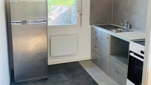 Uma cozinha compacta com geladeira, forno e pia.