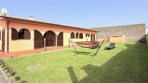A building with arched windows and a grassy courtyard.