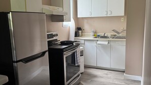 Eine Küche mit Kühlschrank, Herd, Backofen und Schränken.