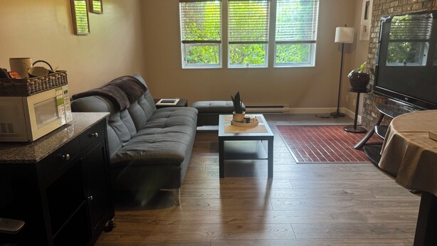 Ein Wohnzimmer mit einer Couch, einem Couchtisch, einem Fernseher und einem Kamin.