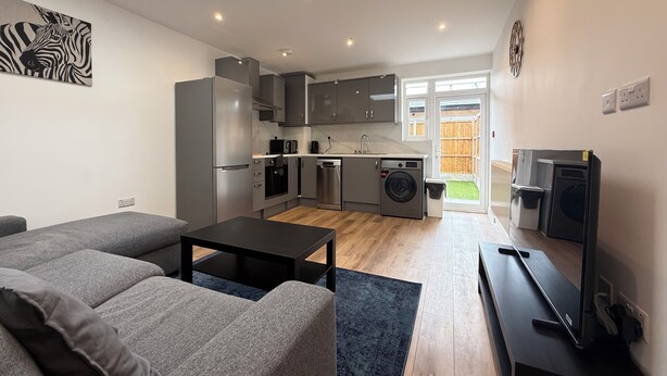 Un appartement moderne comprenant un espace de vie, une cuisine et un espace buanderie.