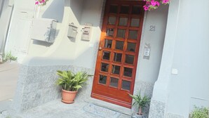 A building entrance with a wooden door, potted plants, and a mailbox. - The Lake House Cernobbio -  Village Center, Walk to Lake (Cernobbio)