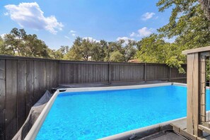 A swimming pool with a wooden deck and a wooden fence. - Austin Retreat with Private Pool l Mins to Downtown! (Austin)