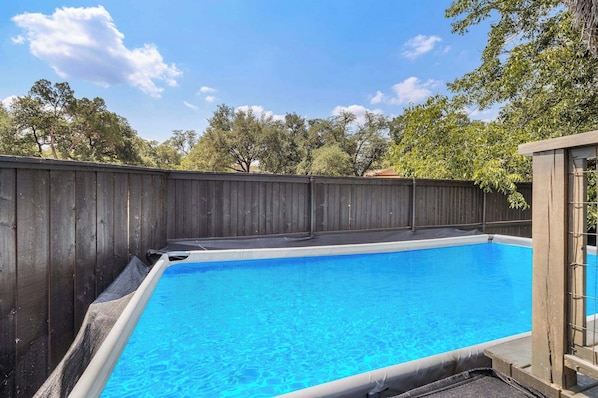 Una piscina con cubierta de madera y valla de madera.