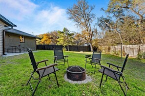 A backyard with a fire pit and four chairs arranged around it. - Austin Retreat with Private Pool l Mins to Downtown! (Austin)