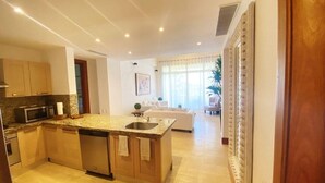 Una cocina moderna con encimeras de granito, lavavajillas integrado y una isla central con fregadero.