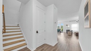 En modern inredning med en trappa, ett matområde och ett vardagsrum med utsikt.
